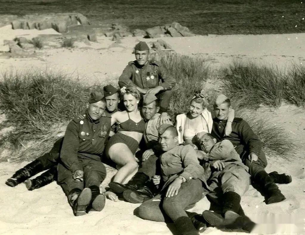 1946年，一群苏联士兵与两个德国女孩的合影，照片中的两名德国女孩穿着暴露，在一