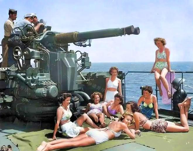 1945年，美国一艘军舰上，3名海军正在对舰炮进行日常检修，而甲板上，8名身穿比
