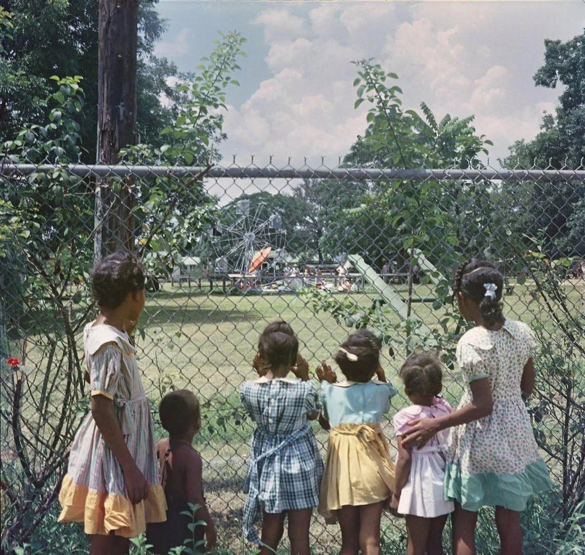 1956年，美国，一群黑人小朋友眼巴巴地望着附近的游乐场，他们知道只有白人才能进