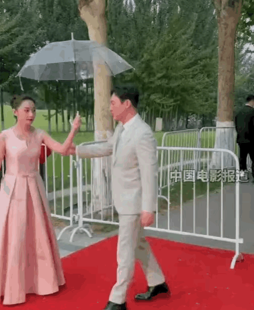 张颂文演技好不说还很绅士平易近人！
在红毯上，张颂文温柔的给礼仪小姐让伞并说:“