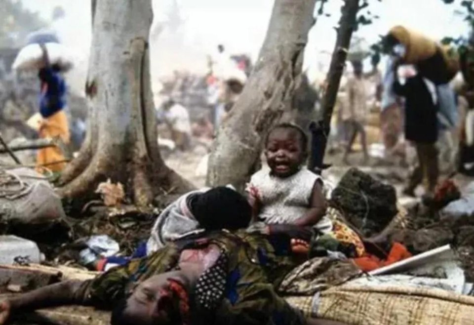 #历史那些事[超话]#卢旺达大屠杀发生时，一个可怜的孩子趴在母亲身上哭，被记者拍