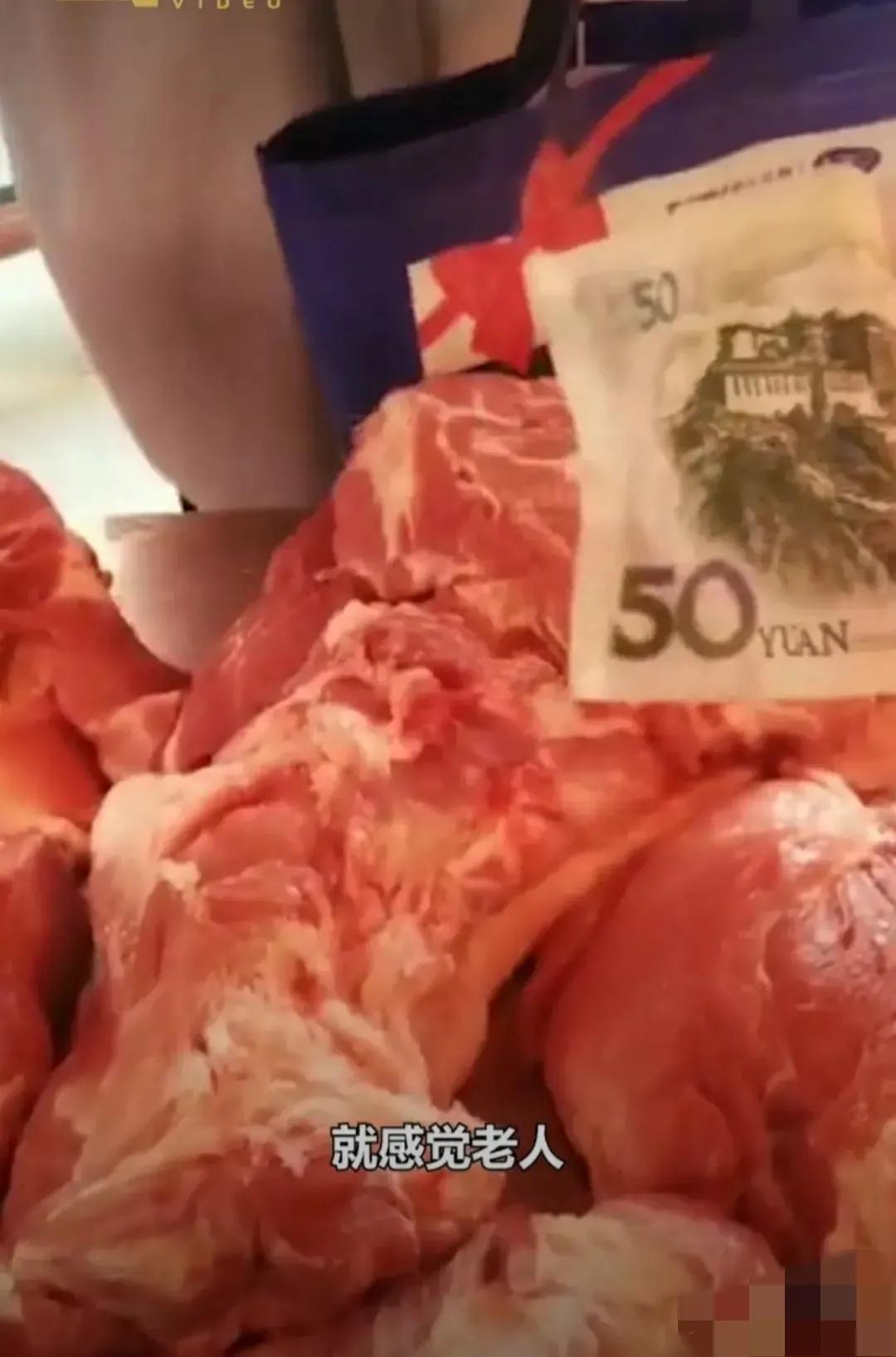 残疾老人去肉摊买肉，递给卖肉的姐姐50元钞票。姐姐拿到钱后，摇了摇红色的钞票，假