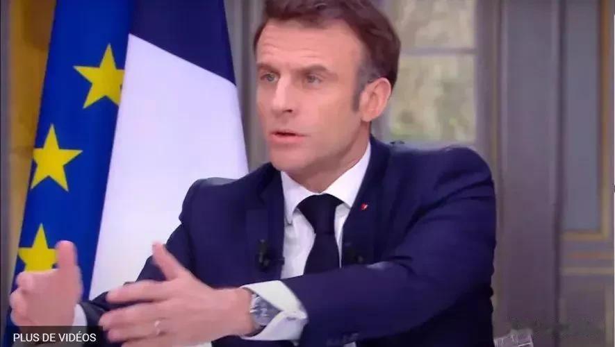 接受关于养老金改革重要性的采访时，法国总统埃马纽埃尔·马克龙试图偷偷摘下一块昂贵