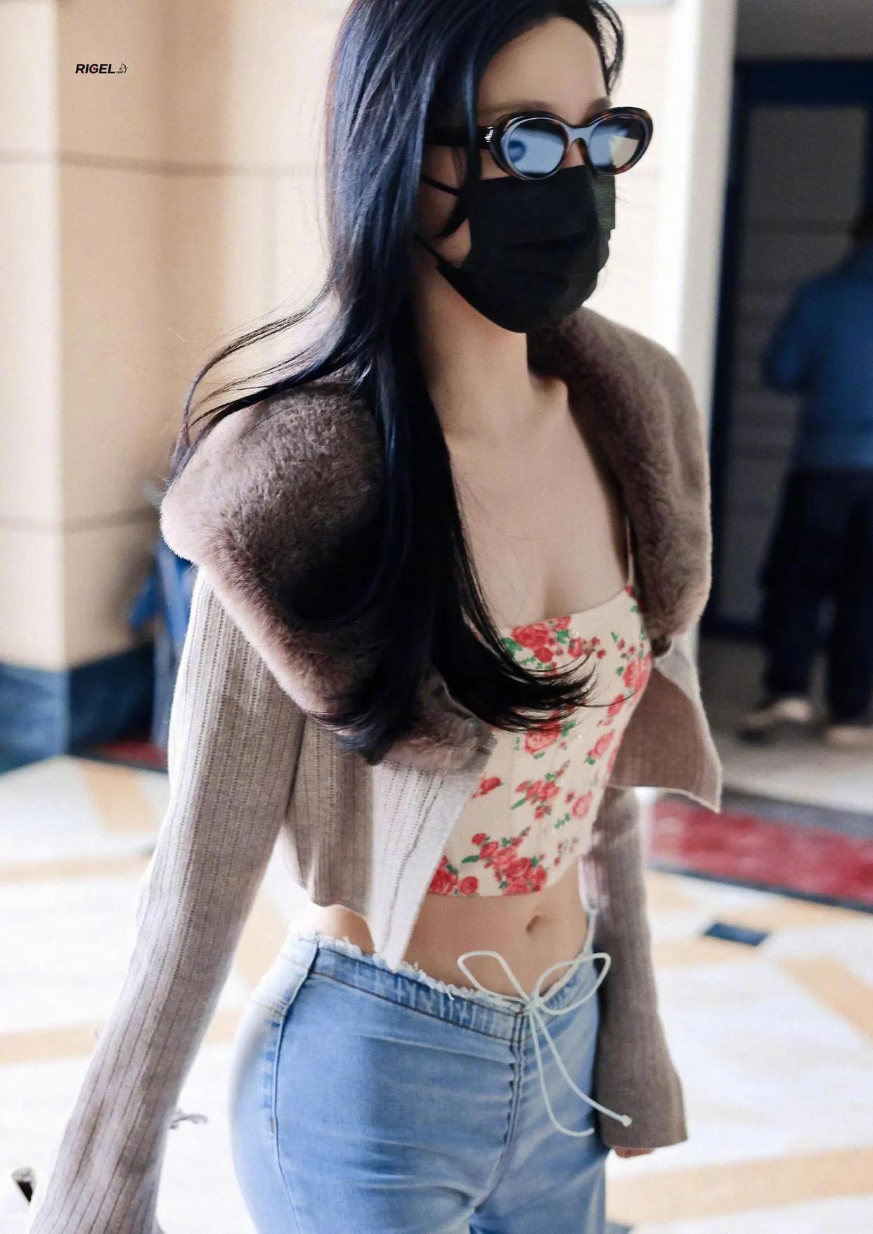 她通过紧身牛仔裤勾勒出来的臀部与露出来的腰肢形成完美对比，正面看是个s型标准身材