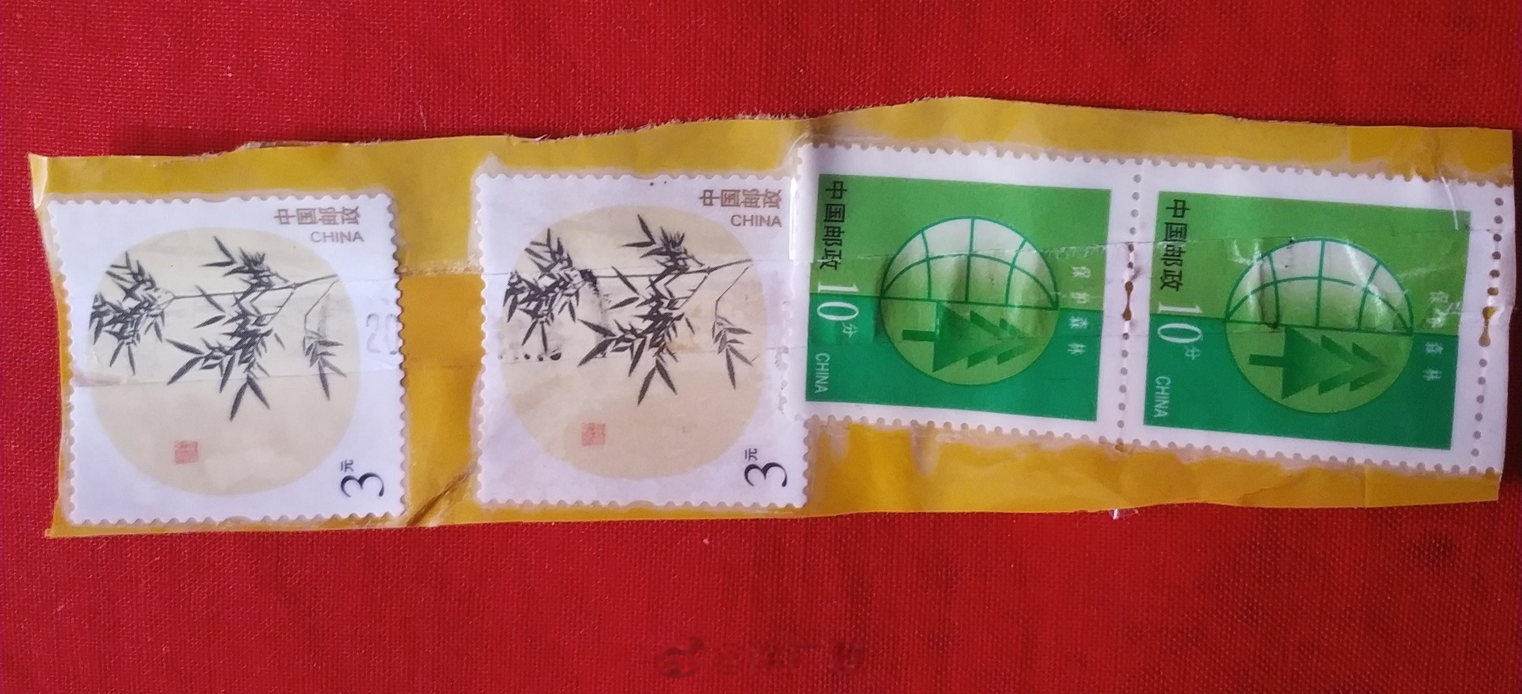 可惜这四枚邮票是用透明胶布贴在邮件上的，胶布直接把邮票覆盖上了。要想分离开不容易