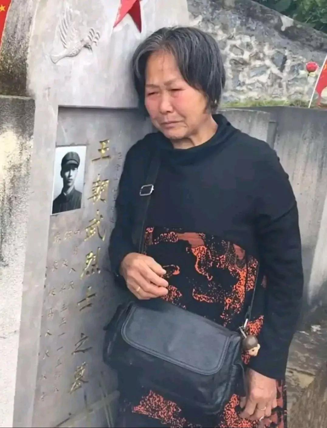 这张照片拍摄于云南省麻栗坡烈士陵园，一位老母亲靠着儿子的墓碑默默流泪，从四川到云