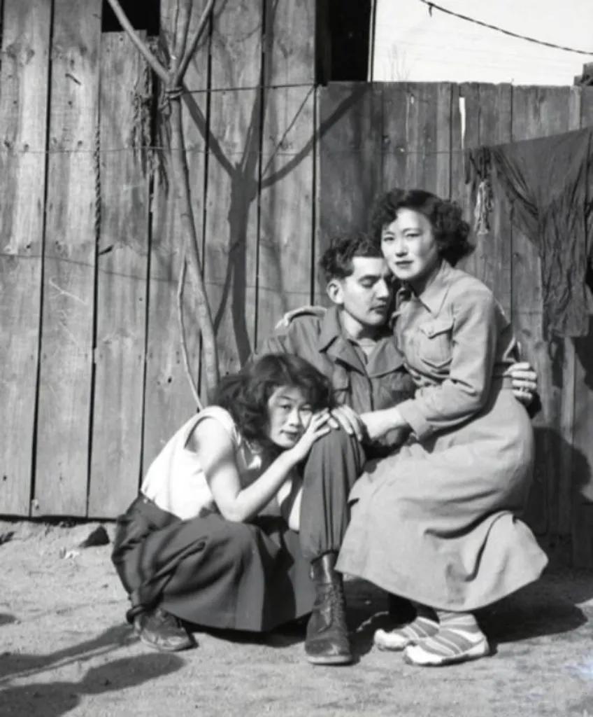 上世纪60年代的韩国，一个美国大兵左拥右抱着俩美女，一脸幸福满足的样子。
这两个