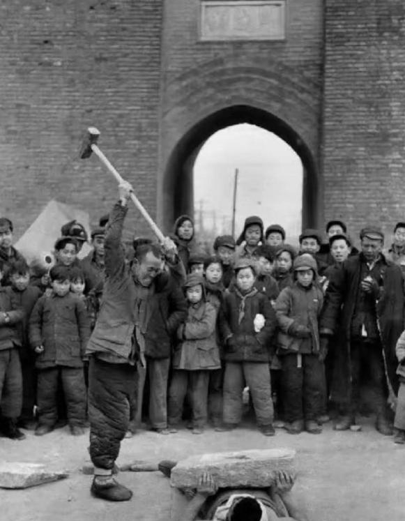 历史老照片：
上世纪五十年代初，北京，正在表演杂技的两个艺人。
周围围满了观看的