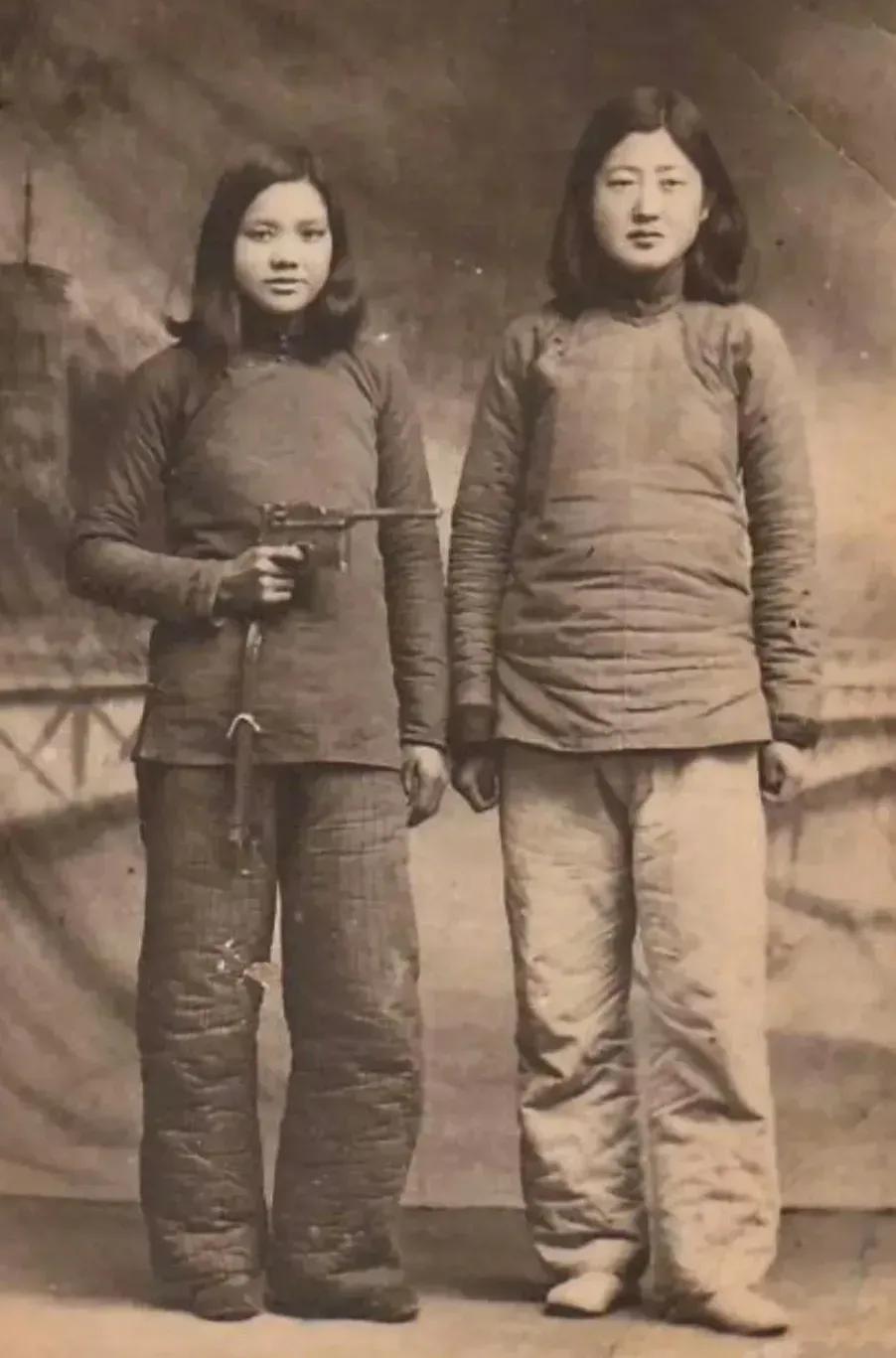 这是一张挺奇怪的老照片，无法分辨出照片拍摄的具体年代，照片中的两个姑娘身材高挑，