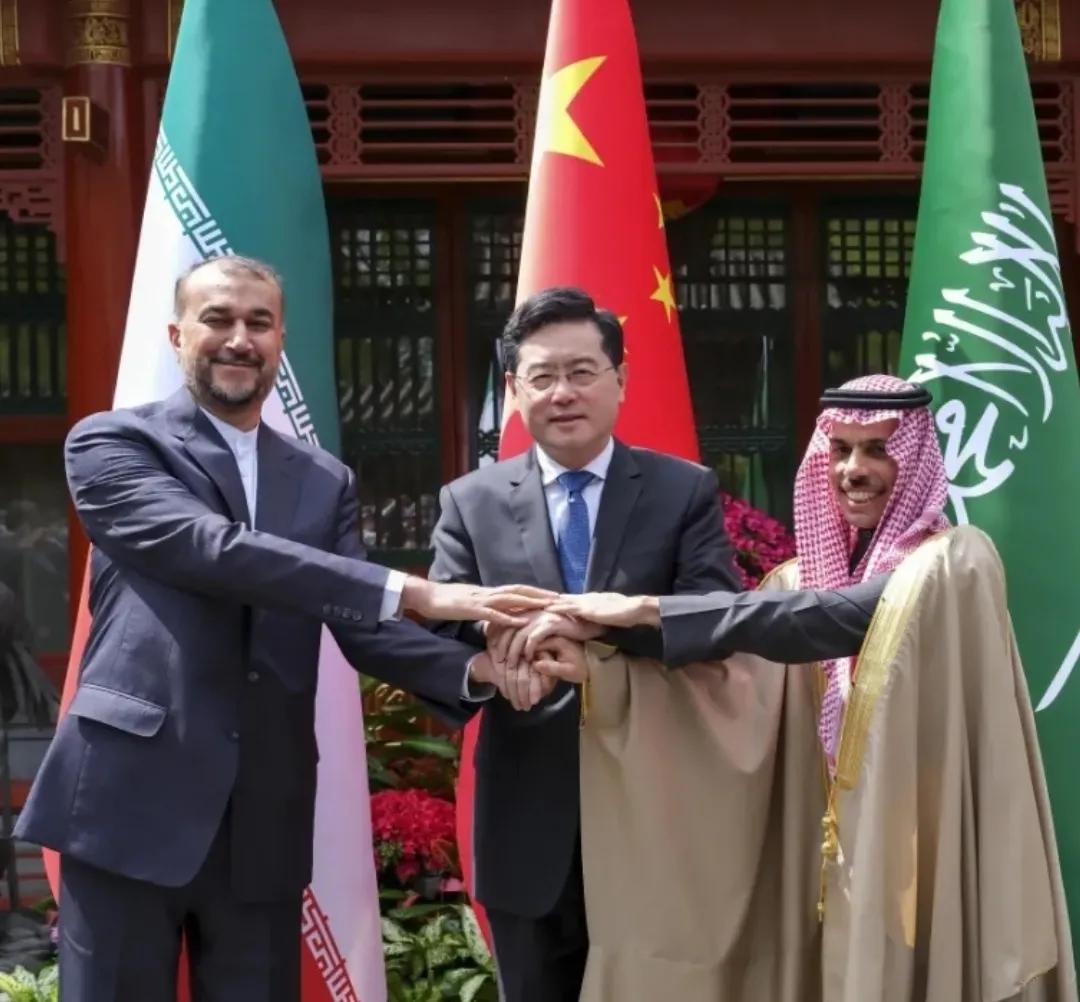 4月6日，北京，三双手紧紧地握在一起，中间的是我外长秦刚，左右分别是伊朗和沙特外