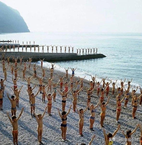 深呼吸，臂敞开，不要着急，三四个1985年海边的少先队营地的孩子们做早操。
在苏