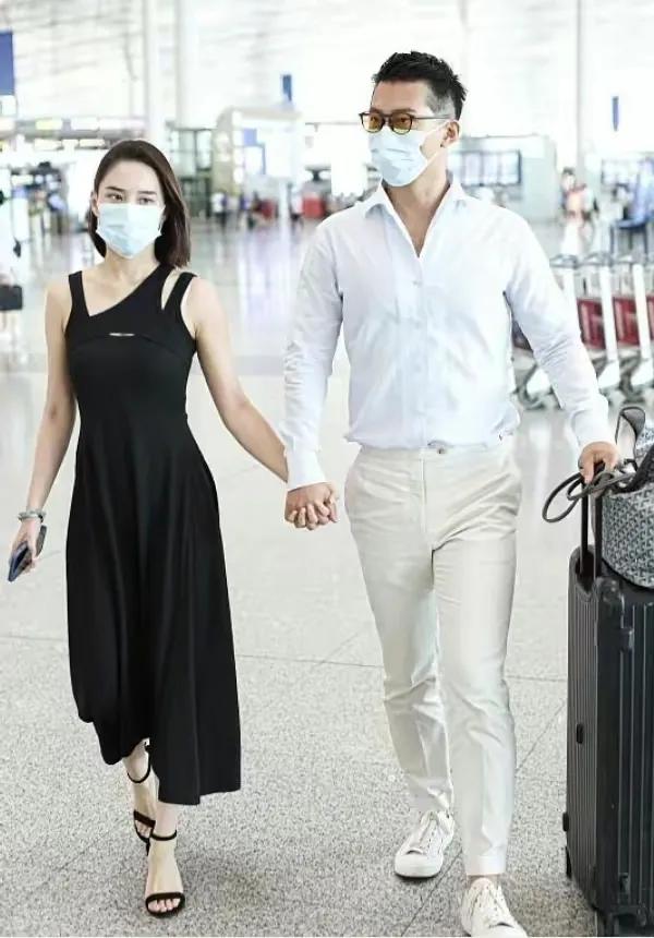 ​何超莲和窦骁十指相扣，婚期将近的他俩真是幸福的一对。

何超莲一款简单的小黑裙