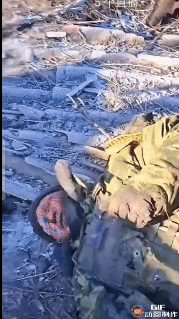 两名乌军发现一名满身霜雪的阵亡俄军士兵，先是用脚踹，又是拿出军刀比划着吓唬人，最