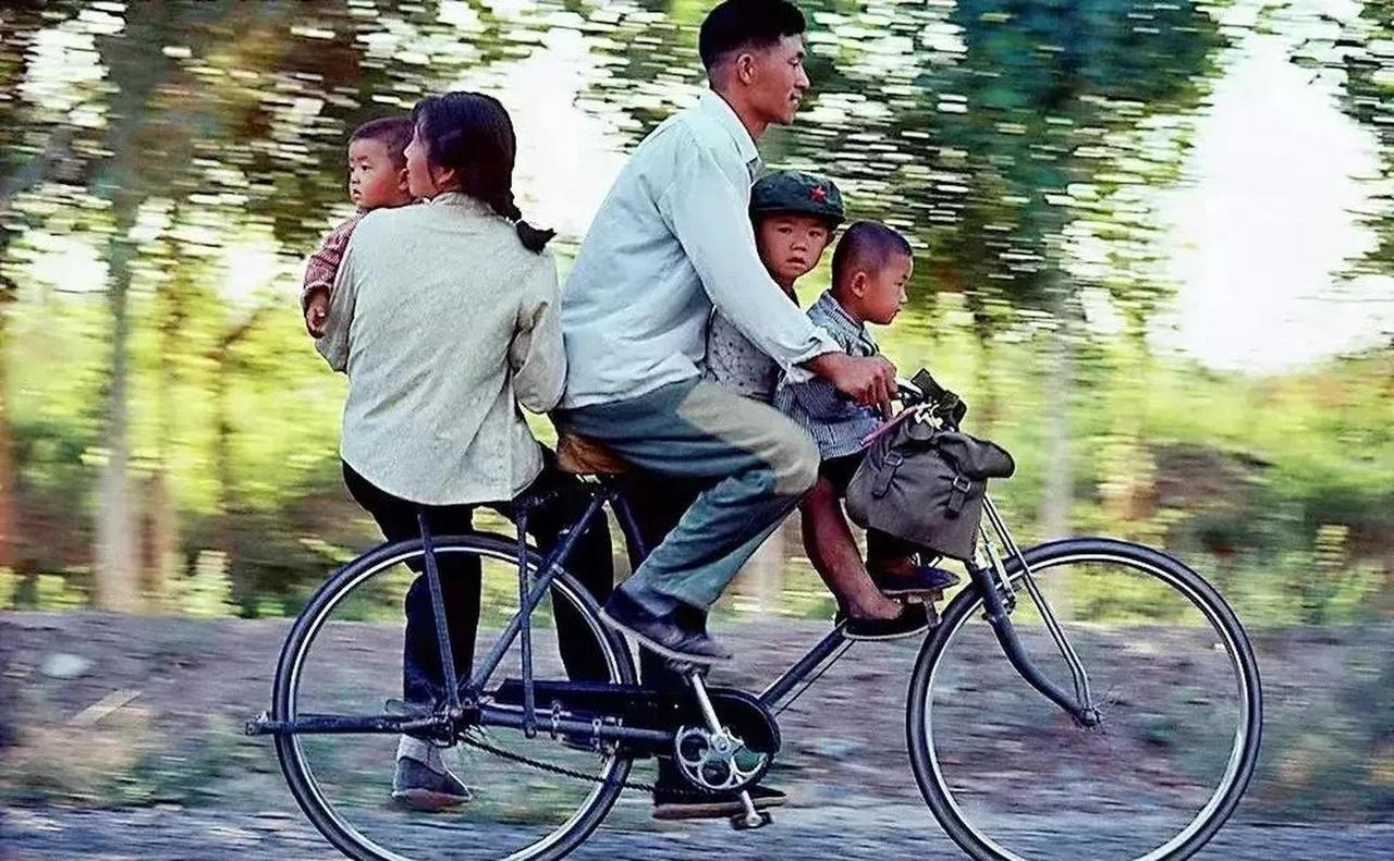 上世纪70年代的农村大路上，一家五口人骑在一辆自行车上。这个场景让人觉得温馨而幸