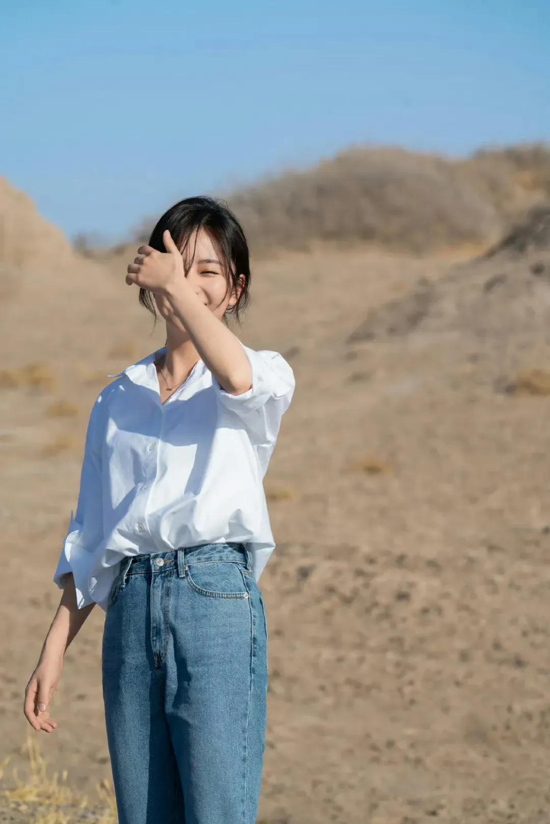 谭松韵公路随拍，穿基础白衬衣，扎低马尾，下搭蓝色牛仔裤，打扮得低调大气，简约时尚