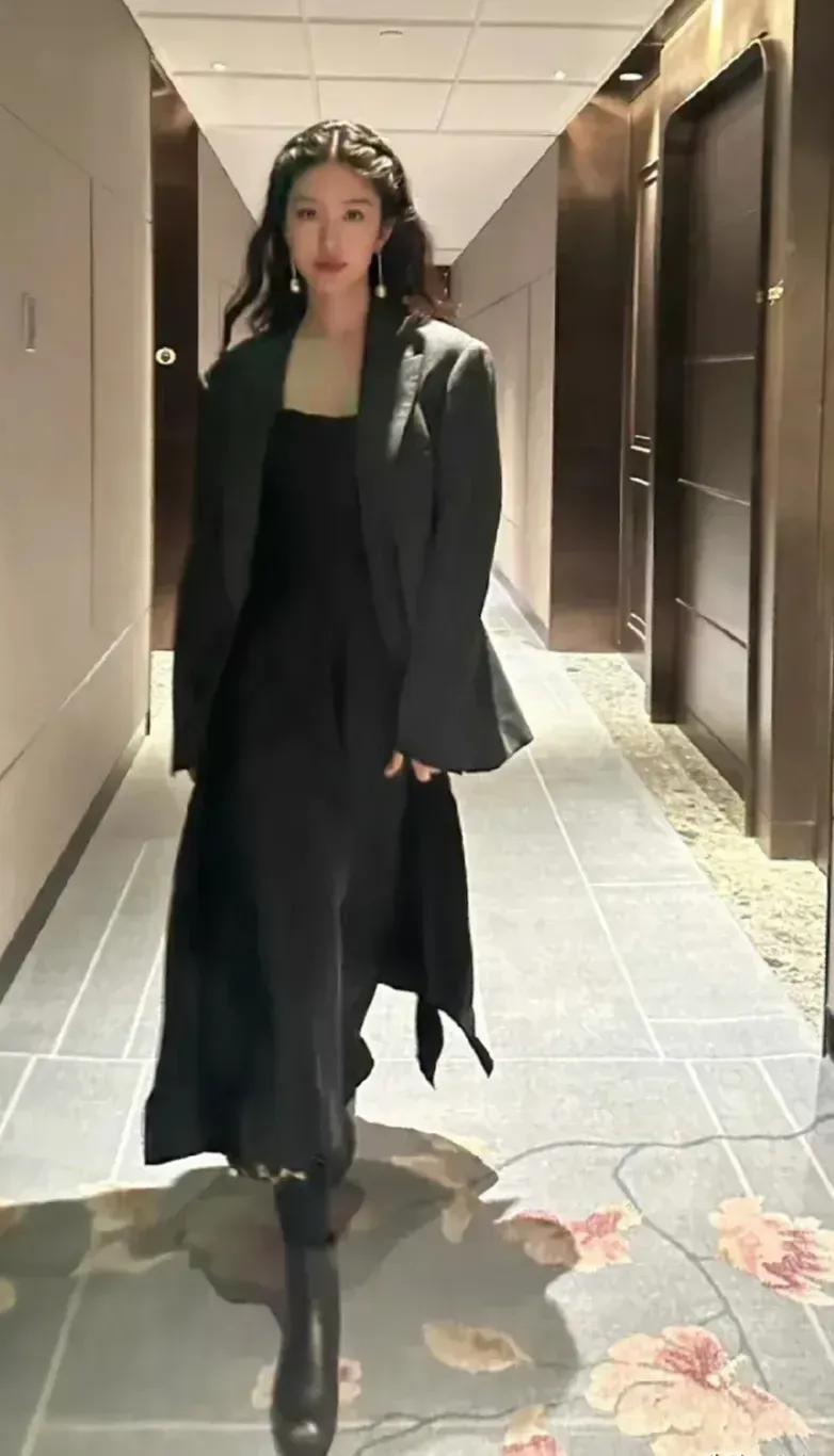 杨采钰摆拍造型大气有范，一袭黑色西装，出镜尽显干练优雅。
西服内搭同色系吊带裙，