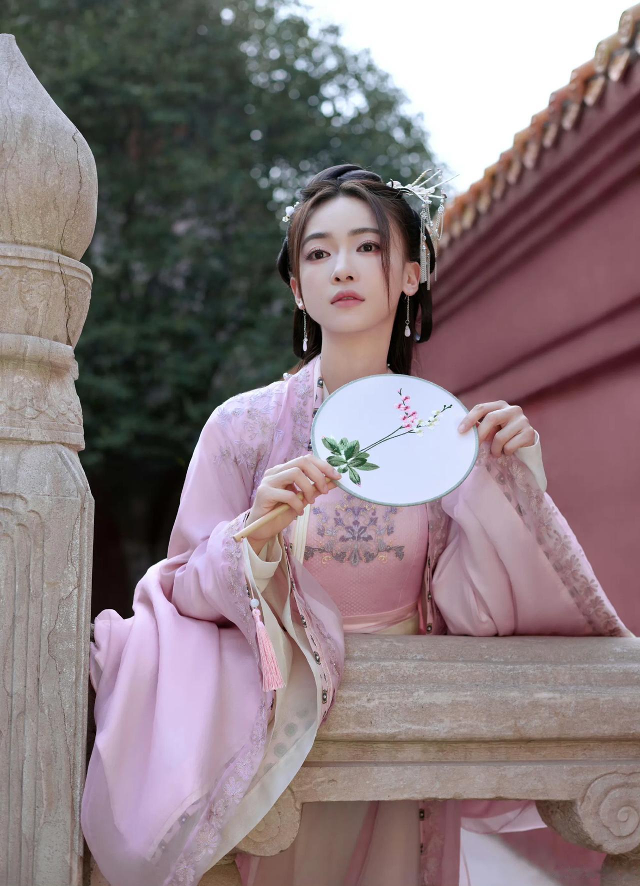 吴谨言

故宫飘着树枝上落下来的花，
一簇一簇地，
好不热闹，
你一身粉红色古装