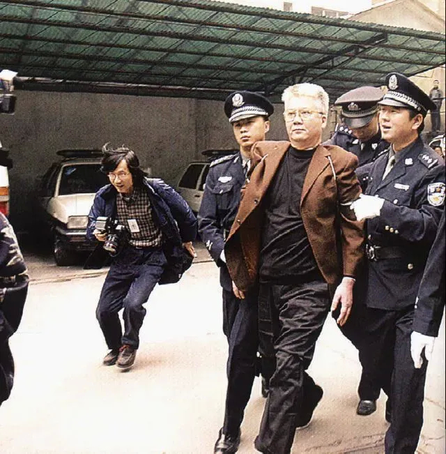 2003年，胡启能被押赴刑场时，一张罕见的镜头，照片中的他头发花白，本该是快要退