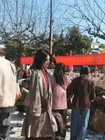 赵丽颖肖央《虎狼之路》云南拍摄路透释出，照片中赵丽颖中长发搭风衣提着行李箱，表情