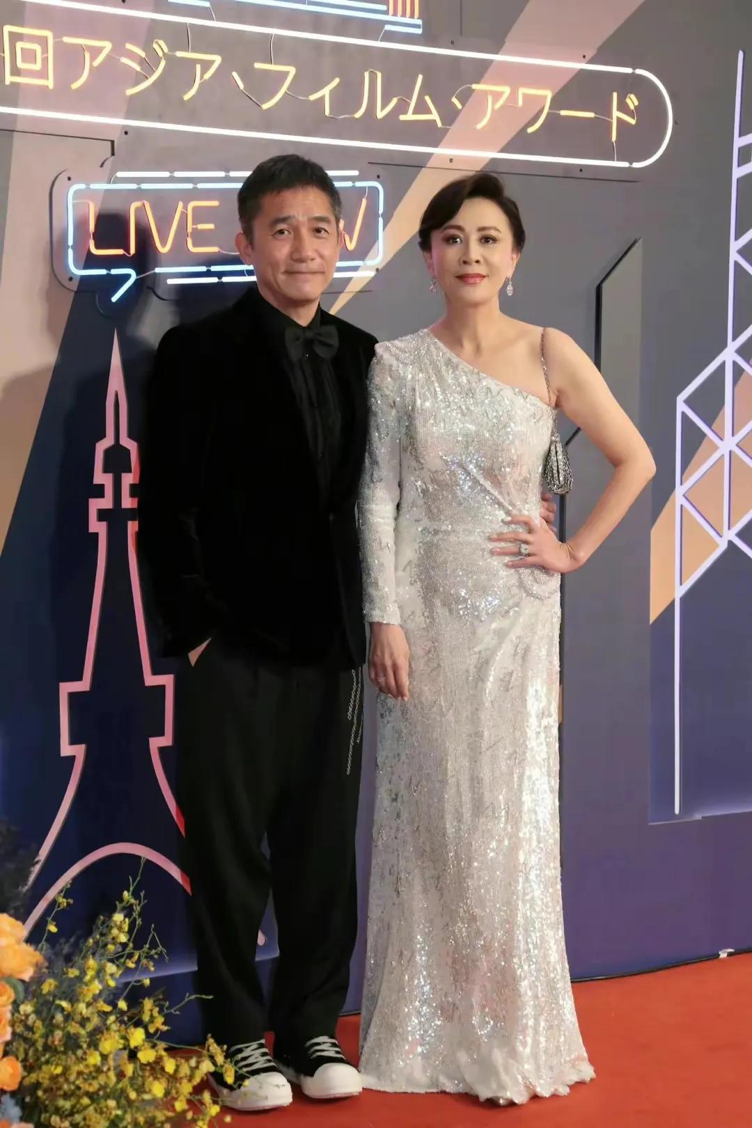 刘嘉玲梁朝伟夫妇参加16届亚洲电影大奖颁奖仪式，梁朝伟穿黑色西服内搭同色系衬衫，