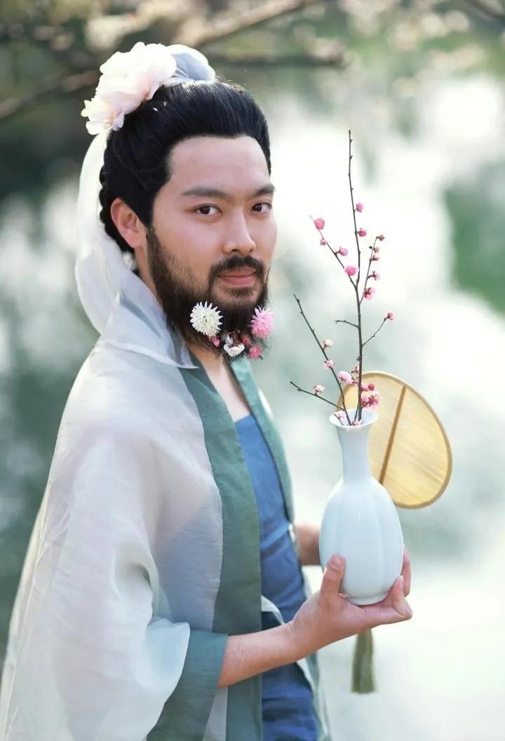 这个大胡子男人在胡子上簪花的样子很妖娆，虽然这样子让人很想打他一顿，但是细品还是