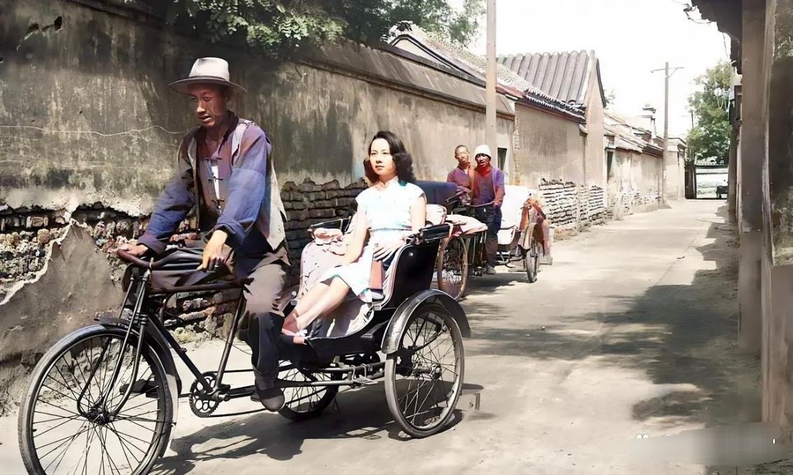 #历史那些事[超话]#民国时期，一个年轻女子坐人力车走过一条小巷。女孩烫着大波浪