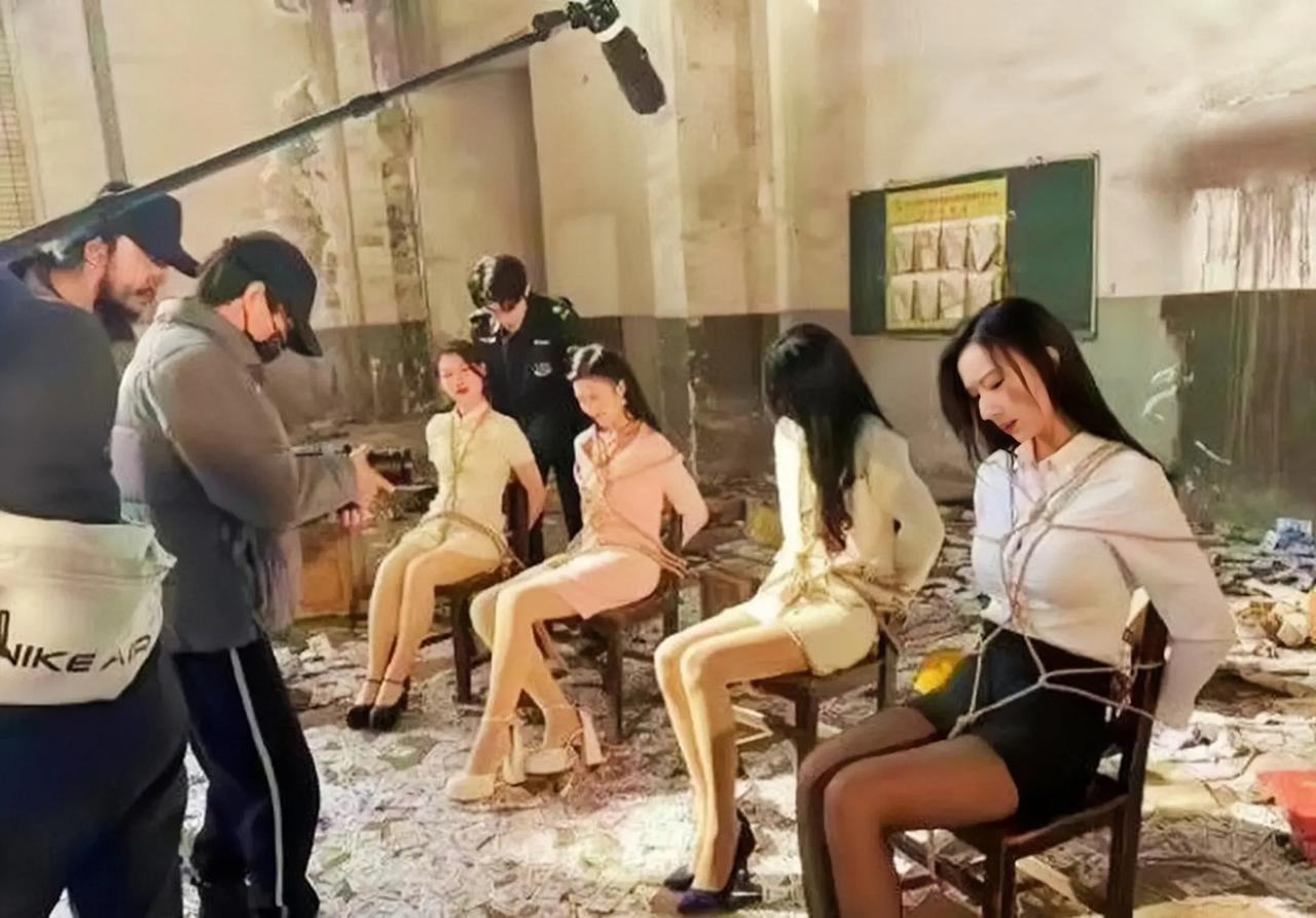 这是一部剧的拍戏现场，在一个废弃的仓库里，四个美女被绑在椅子上，场面很香艳也很奇