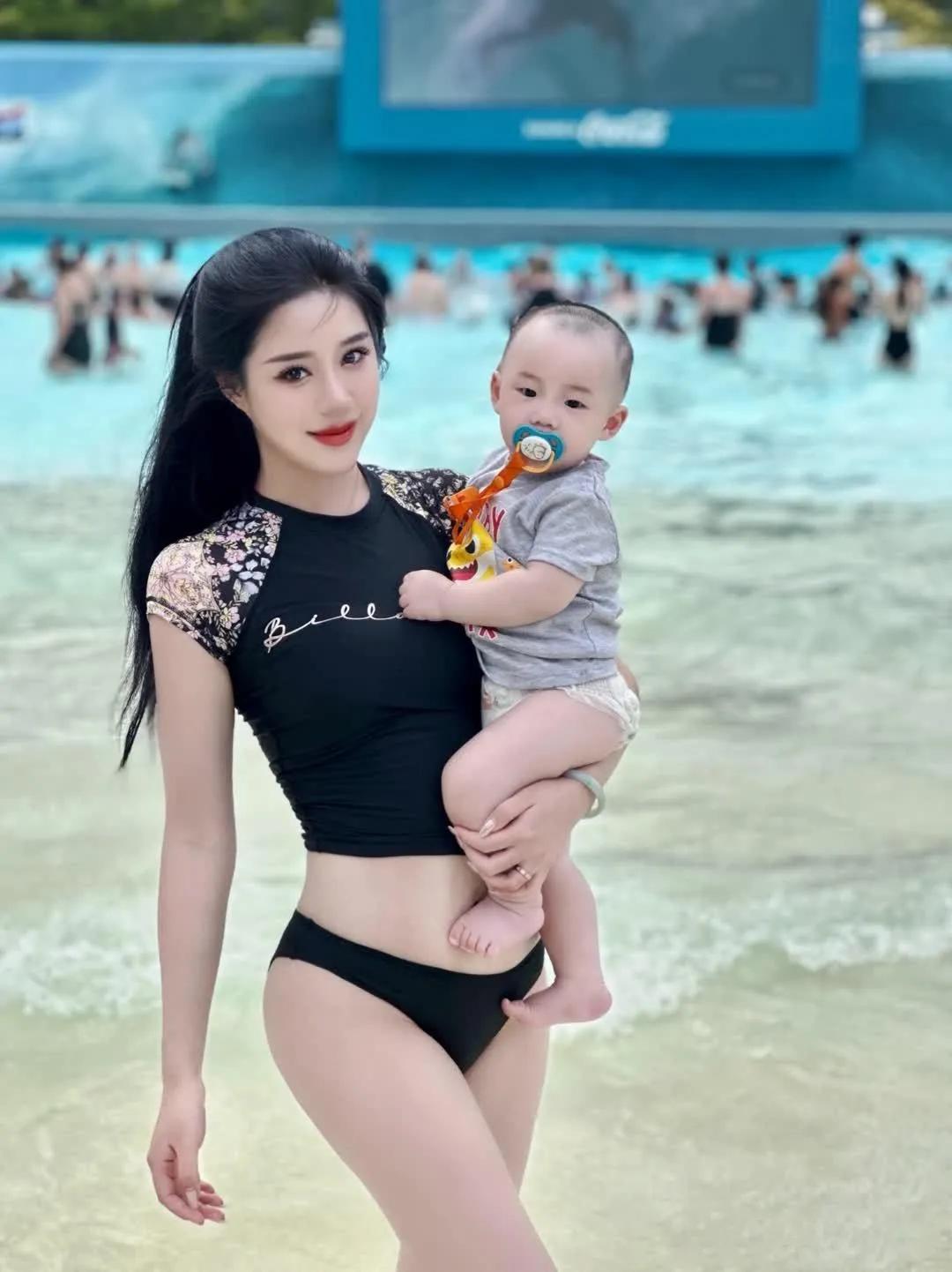 一个年轻辣妈和她的一双儿女在海边游玩的情景，生了俩孩子身材还这么好，真的让人羡慕