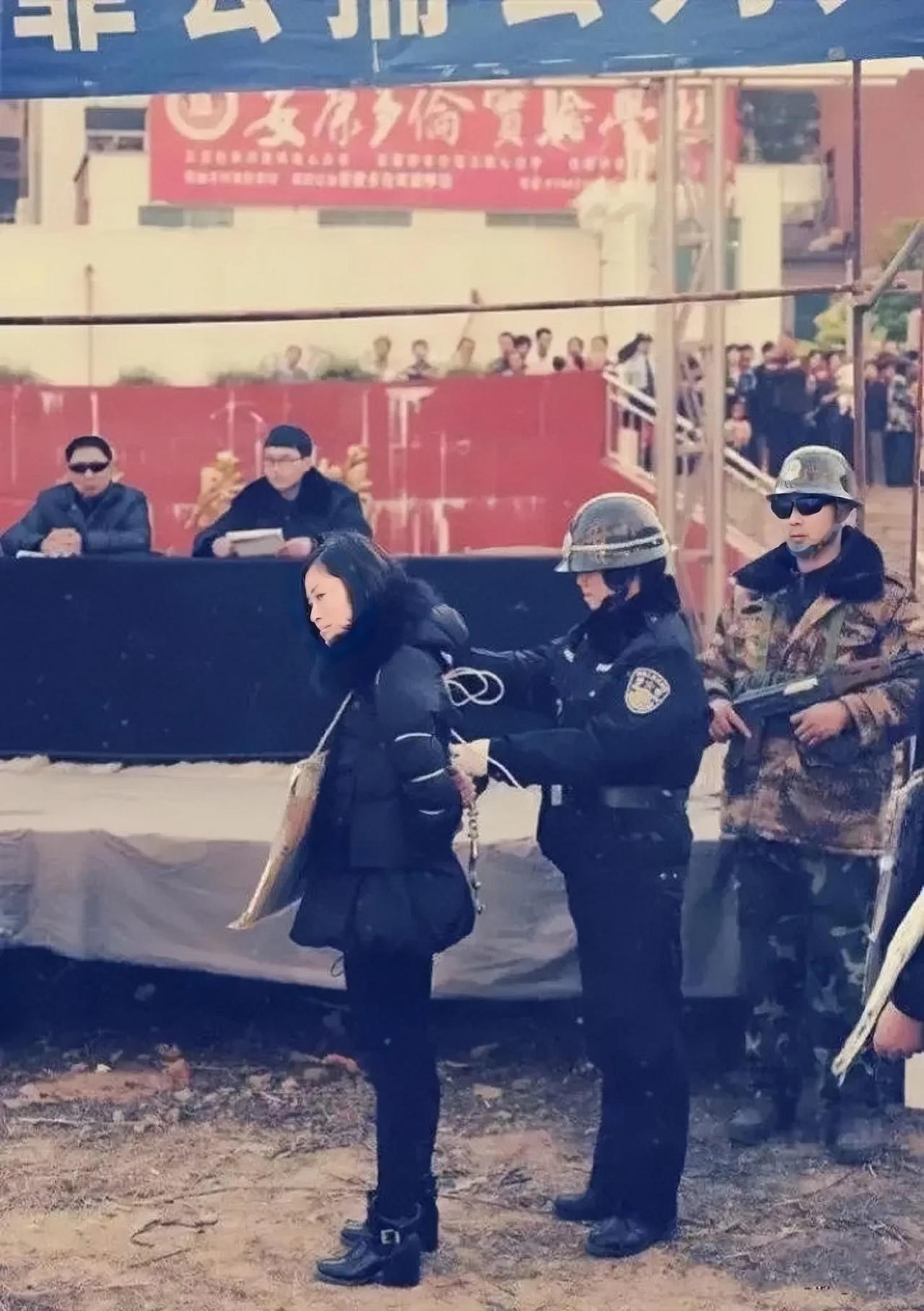 上世纪90年代，某地的一场公审大会现场，一个被绑起来的女犯人。
这个女犯人侧颜来