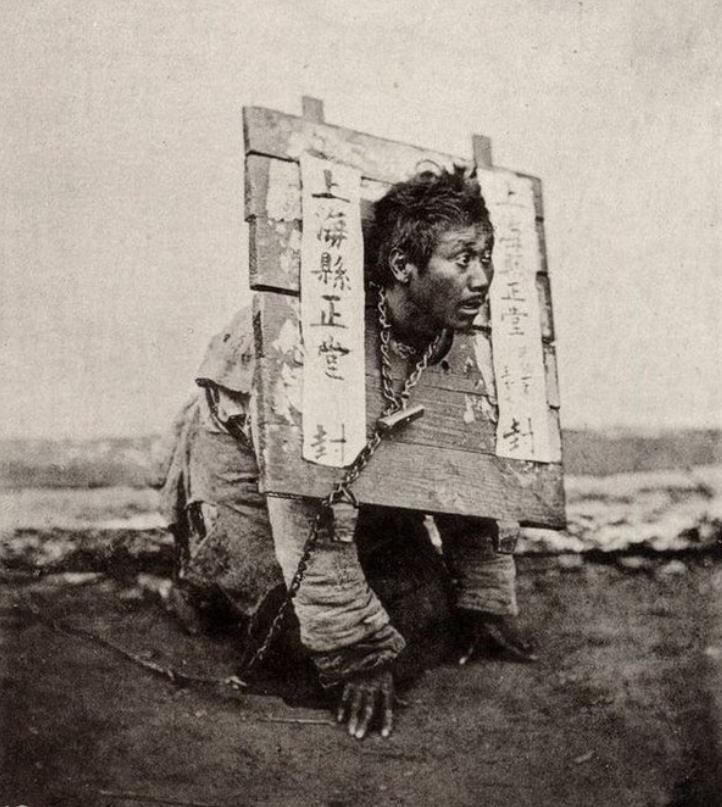 【犯罪的代价】
这是一张19世纪上海囚犯的照片，拍摄时间约为1870年，画面中的