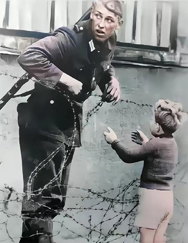 1961年，德国东柏林，一位东德士兵正在帮助一名素不相识的小男孩翻越柏林墙，而随