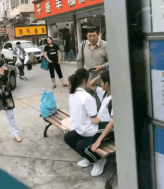 大叔教训的对！两名身着校服的少年男女，在大庭广众之下以一种非常亲密的姿势坐在一起