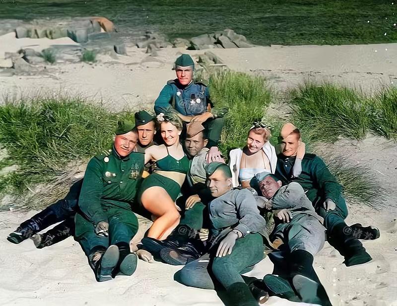 1945年，德国，7名苏联士兵和2名德国女子在海边拍下了这张暧昧的合影。镜头中的