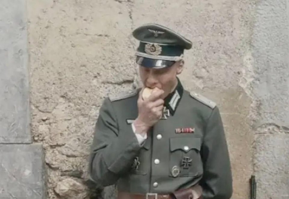 #历史那些事[超话]#二战期间德国国防军的一名中尉军官，他正靠着墙吃苹果，享受着