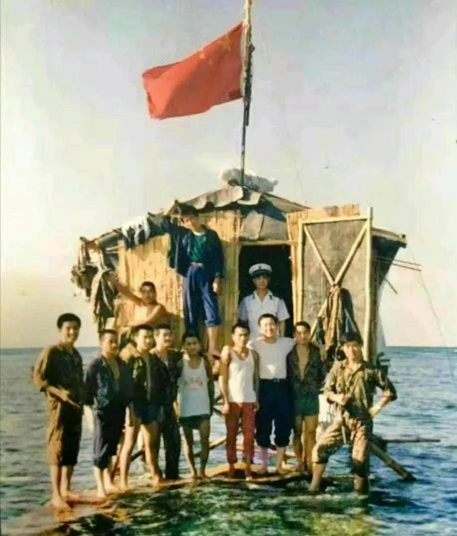 1988年南海东门礁第一代茅草木制高脚屋，十几名战士挤在一个不足10平米的房子前