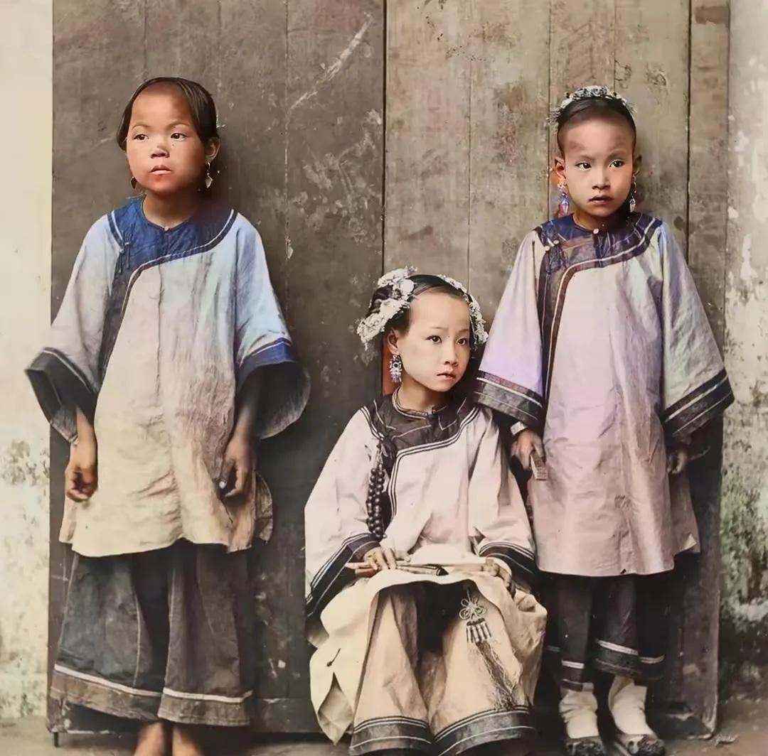 清末时期的一张老照片，一个富人家的千金小姐和服侍她的两个小丫鬟。
主仆三人年龄都