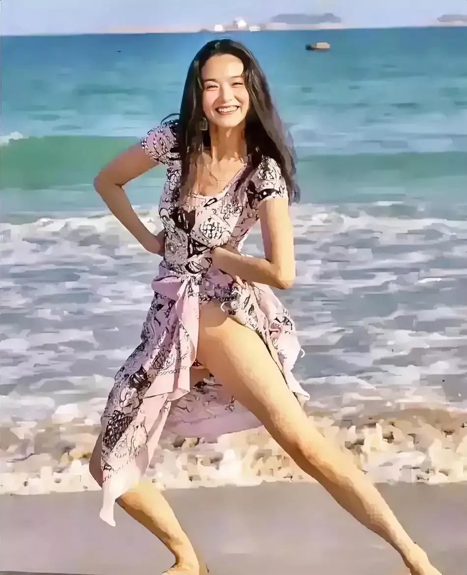 这是林青霞年轻时在海边玩耍时，拍下了这张煽情迷人的照片。

照片中的她穿着一件粉