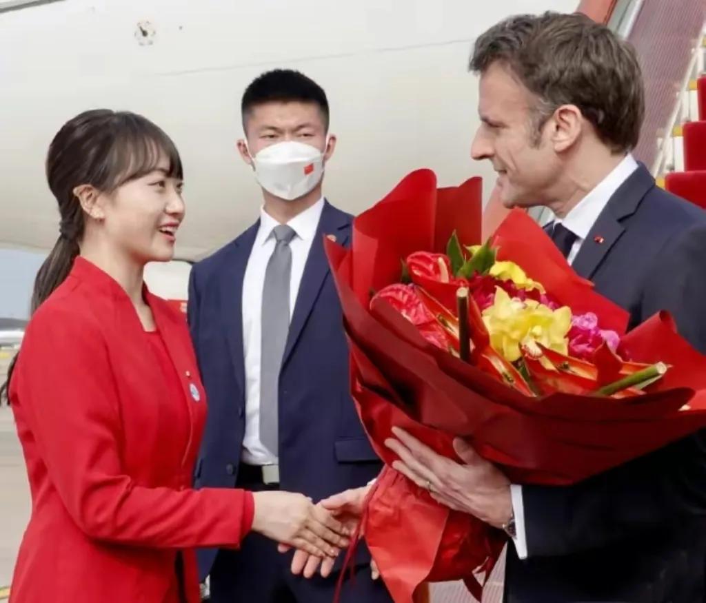 在机场给马克龙献花的红衣女孩的正面照来了。
这个红衣女孩脸庞极具东方美的韵味，一